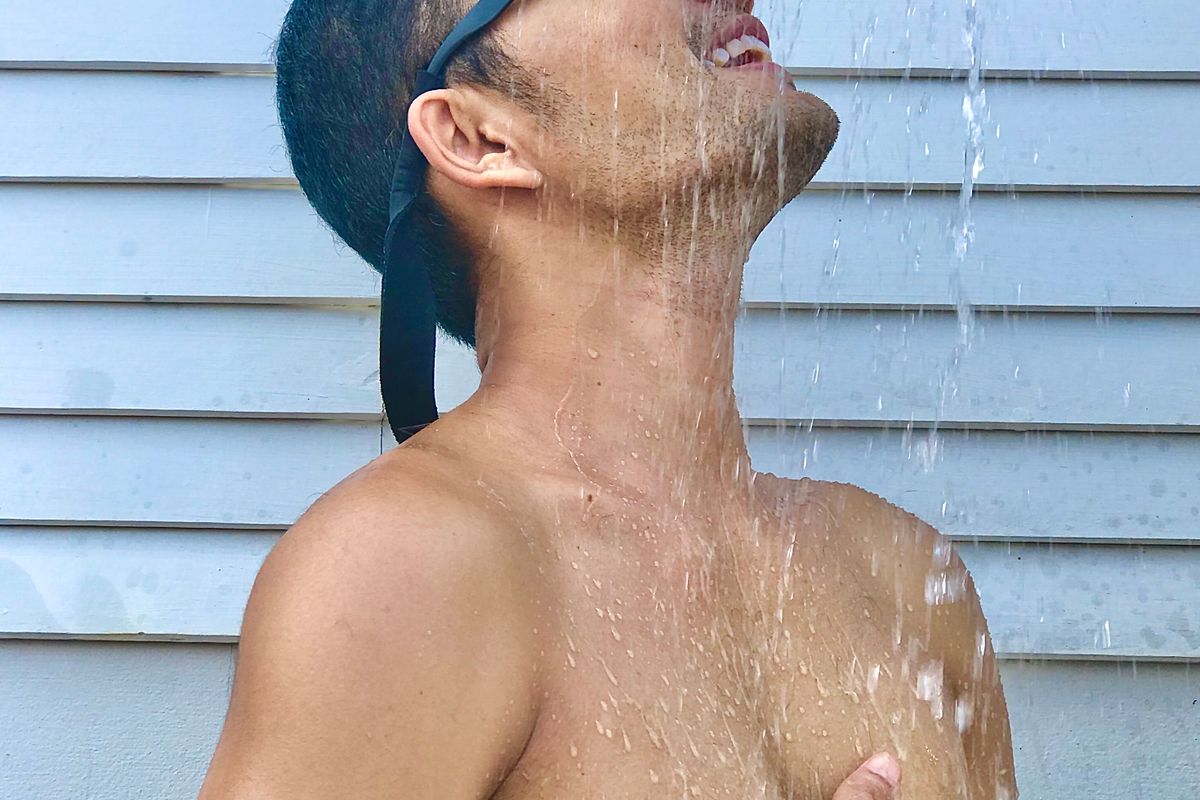 Steam rising from a shower running over a hand at the wrist